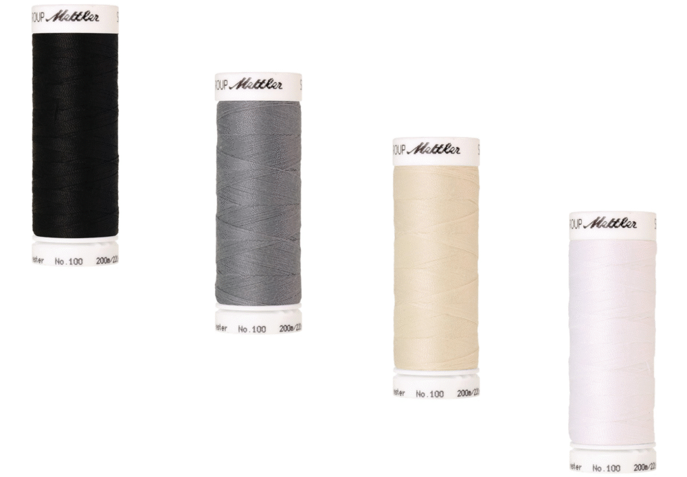 Bobines de fils Mettler Seralon 200m en couleurs blanc, écru, gris et noir, prêtes pour la couture.
