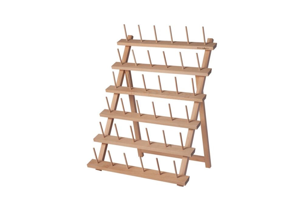Porte-bobines Milward pour 36 bobines de fil à coudre, couleur bois clair, rempli de fils colorés, sur un établi de couture.
